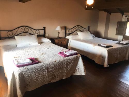 1 dormitorio con 2 camas y toallas. en CASA RURAL LA CABRERA, en Casas del Castañar
