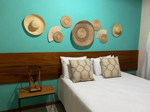 a bedroom with a bed with hats on the wall at Pousada Carapeba in São Francisco
