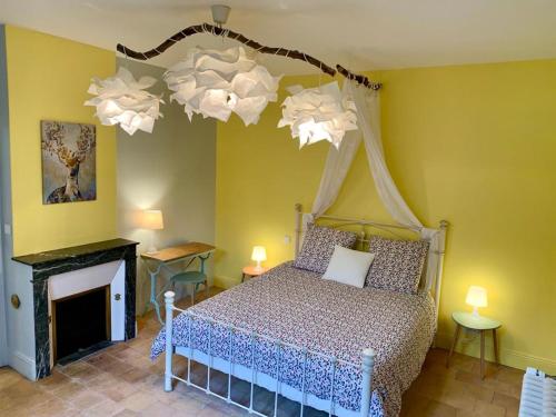 a bedroom with a bed and a chandelier at Le Clos de la Canardière in Savigny-sur-Braye