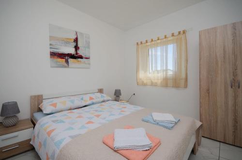 a bedroom with a bed with towels on it at Apartments Slobodanka in Lopar