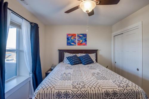 a bedroom with a bed with a ceiling fan and a window at The Captains Lookout Sleeps 6, Hot Tub, Pet Friendly, Ocean View in Depoe Bay