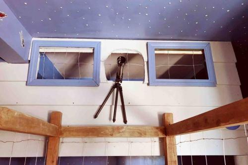 a camera hanging from a wall with two windows at Sol-O-Cien Estrella No Check Out Chores in Rosarito