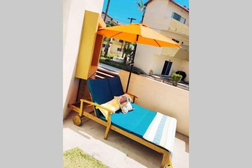 a chair with an umbrella on a balcony at Sol-O-Cien Estrella No Check Out Chores in Rosarito