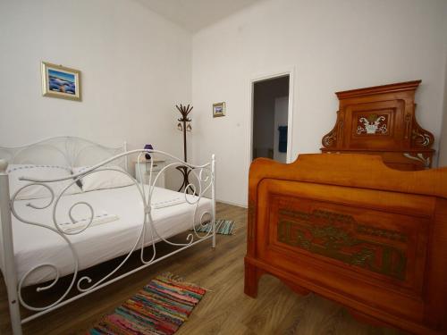 a bedroom with a white bed and a wooden crib at Villa URSULA in Grižane