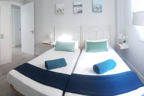 un grande letto con due cuscini blu sopra di Recién reformado, bien situado y comunicado a San Fernando