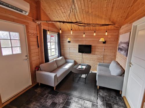 a living room with a couch and a tv at Reipå Camping in Reipå