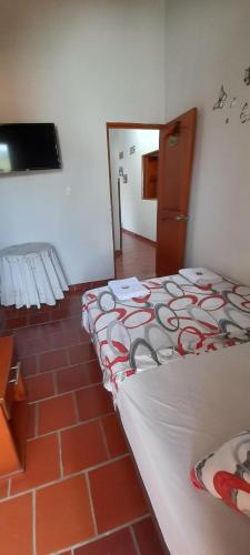 1 dormitorio con 1 cama y suelo de ladrillo en Posada San Luis, en Páramo
