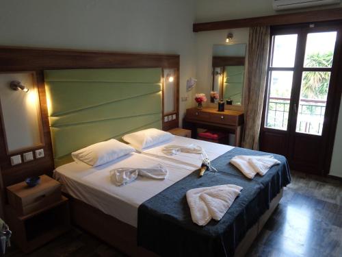 een hotelkamer met een bed met handdoeken erop bij Niki Studios Sea - Front in Petra