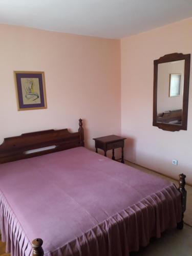 a bedroom with a large bed and a mirror at Rakić apartman in Bajina Bašta