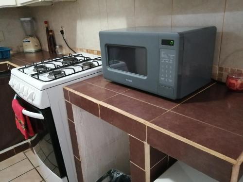 a microwave sitting on top of a stove in a kitchen at Departamento Zona Dorada Mazatlán 6 in Mazatlán