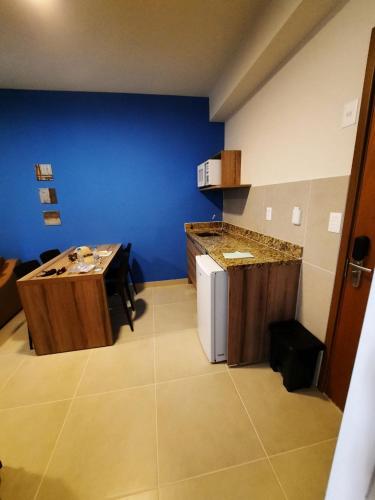 une cuisine avec une petite table et un mur bleu dans l'établissement ONDAS PRAIA RESORT, à Porto Seguro