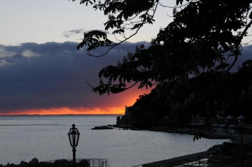 a person standing on the beach at sunset at Villa Tergeste in Trieste