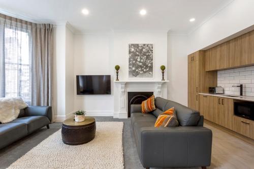 a living room with a couch and a fireplace at Character on Stuart St in Dunedin