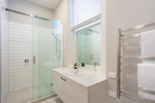 但尼丁的住宿－Character on Stuart St，白色的浴室设有水槽和淋浴。