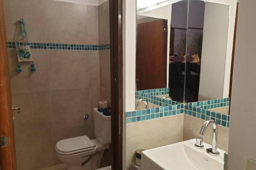 a bathroom with a toilet and a sink and a mirror at La Casa de los Molles in Tilcara