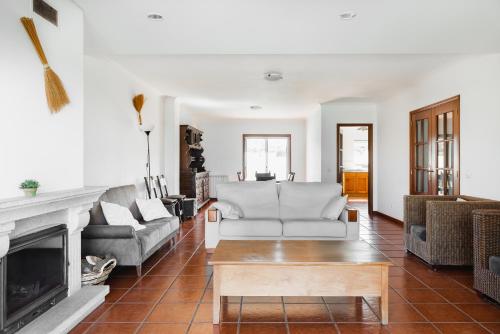a living room with two couches and a fireplace at Gelfa Beach House in Viana do Castelo