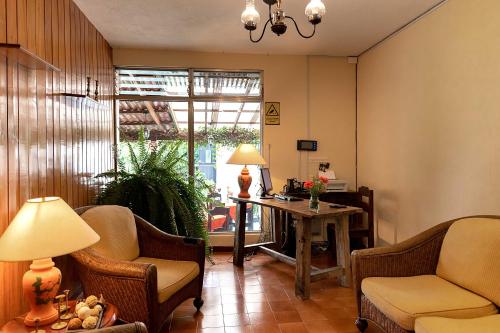 a living room with chairs and a table and a window at Hostal Donde Regina in Guatemala