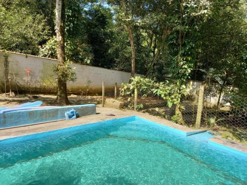 a swimming pool in a yard next to a fence at CHALÉ POUSADA DO SONHO Guapimirim-RJ in Guapimirim