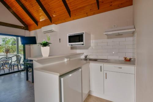 
a kitchen with a sink and a microwave at Desert Palms Alice Springs in Alice Springs
