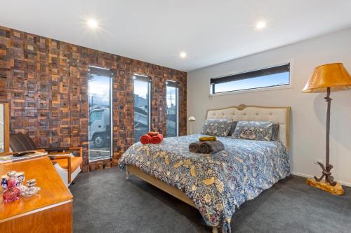 una camera con letto e muro di mattoni di Modern Charm a Dunedin