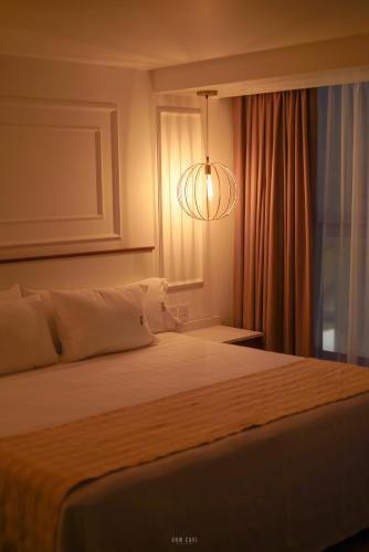 a bedroom with a bed and a chandelier at Six Hotel Guadalajara Degollado in Guadalajara