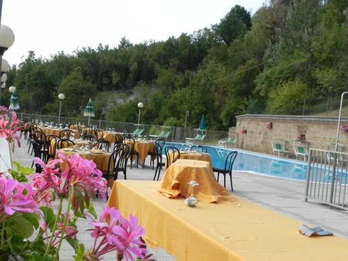 a group of tables and chairs and a pool at Hotel Ducale in Tabiano