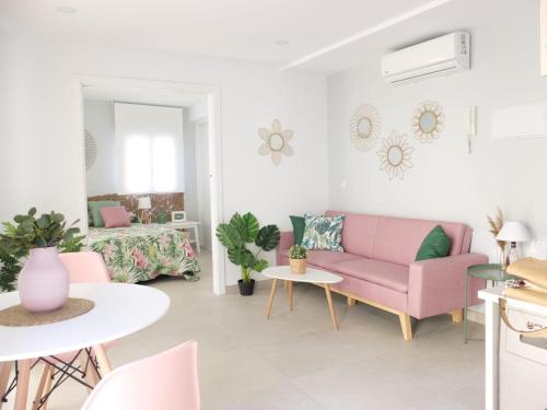 un soggiorno con divano rosa e tavolo di La Torre a Écija