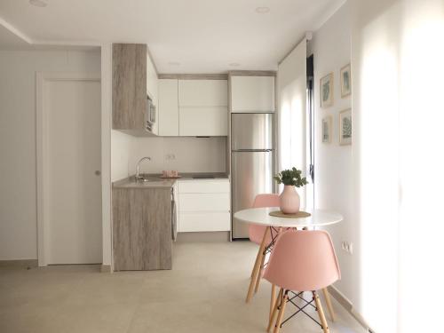 a kitchen with a table and two pink chairs at La Torre in Écija