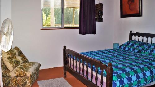 ein Schlafzimmer mit einem Kinderbett und einem Stuhl in der Unterkunft La Chacra Holandesa in Atlántida