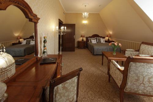 a hotel room with two beds and a desk and a room at Hotel Jarosław in Jarosław