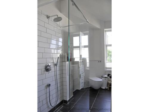 uma casa de banho com um WC e uma cabina de duche em vidro. em ApartmentInCopenhagen Apartment 414 em Copenhague