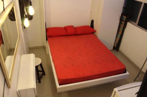 1 cama roja pequeña en una habitación pequeña en Suítes Copa en Río de Janeiro