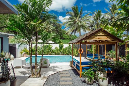 a villa with a pool and a gazebo at Casa Del Sol in Rarotonga