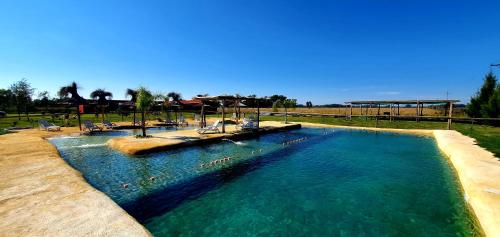 a large pool with blue water in a resort at La Maina Uribe in Uribelarrea