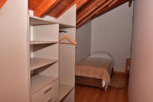 a bedroom with a bed and a closet with shelves at Amarras in Villa Pehuenia
