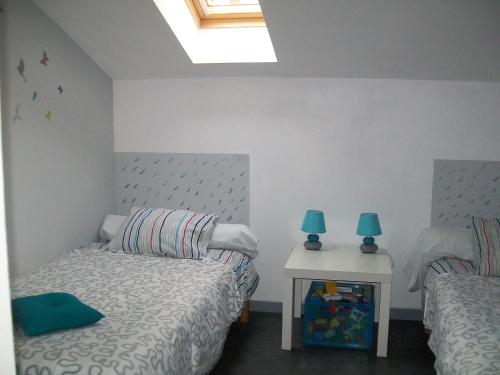 um quarto com duas camas e duas lâmpadas sobre uma mesa em Au Jardin d'Eau em Missillac