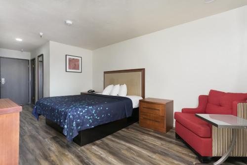a hotel room with a bed and a red couch at Waterloo Inn in Stockton