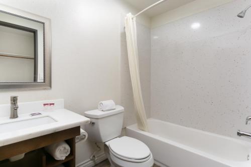 a bathroom with a toilet and a sink and a tub at Waterloo Inn in Stockton