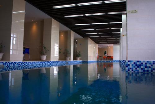 a swimming pool in a building with blue tiles at Lark Hotel in Dar es Salaam
