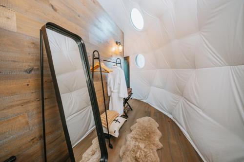 ein Schlafzimmer in einem winzigen Haus mit einem Spiegel in der Unterkunft Cross Hill Glamping in Lake Hawea