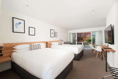 um quarto de hotel com duas camas e uma secretária em Hotel Nelson em Nelson Bay