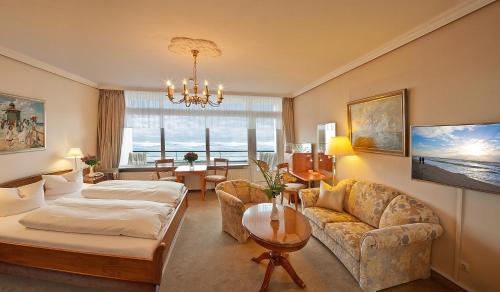 a living room with a bed and a couch at Strandhotel Monbijou GmbH garni in Westerland (Sylt)