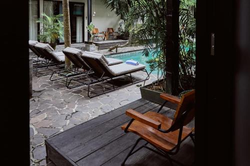 a group of chairs sitting next to a swimming pool at Outpost Ubud Penestanan in Ubud