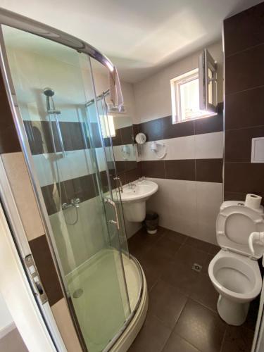 a bathroom with a shower and a toilet and a sink at Solinaria Boutique Hotel in Sozopol