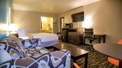 a hotel room with a bed and a couch at Howard Johnson by Wyndham Houston Hobby Airport in Houston
