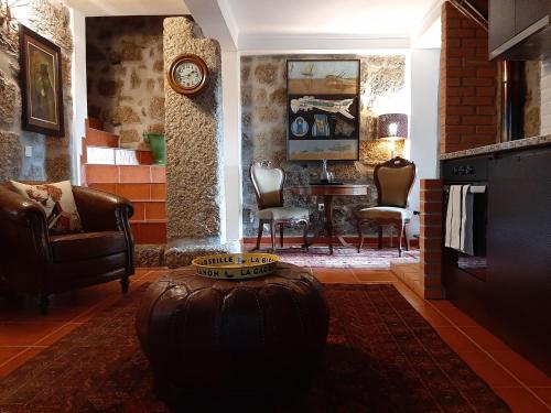 een woonkamer met een tafel en stoelen en een klok bij Anibals Boutique Lodging - Serra da Estrela in Gouveia