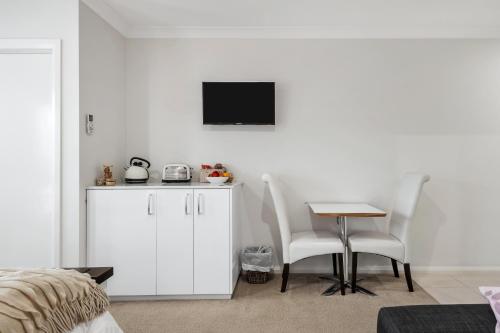 a bedroom with a table and two chairs and a tv at The Oxley Estate in Portarlington