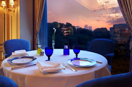 a table with plates and utensils on a table with a view at Hotel Chinzanso Tokyo in Tokyo
