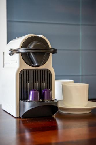 a coffee maker sitting on a table next to cups at Seashells Yallingup in Yallingup