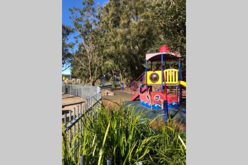 a small train in a park next to a fence at Luxe at Brooklyn - Hawkesbury River Marina in Brooklyn